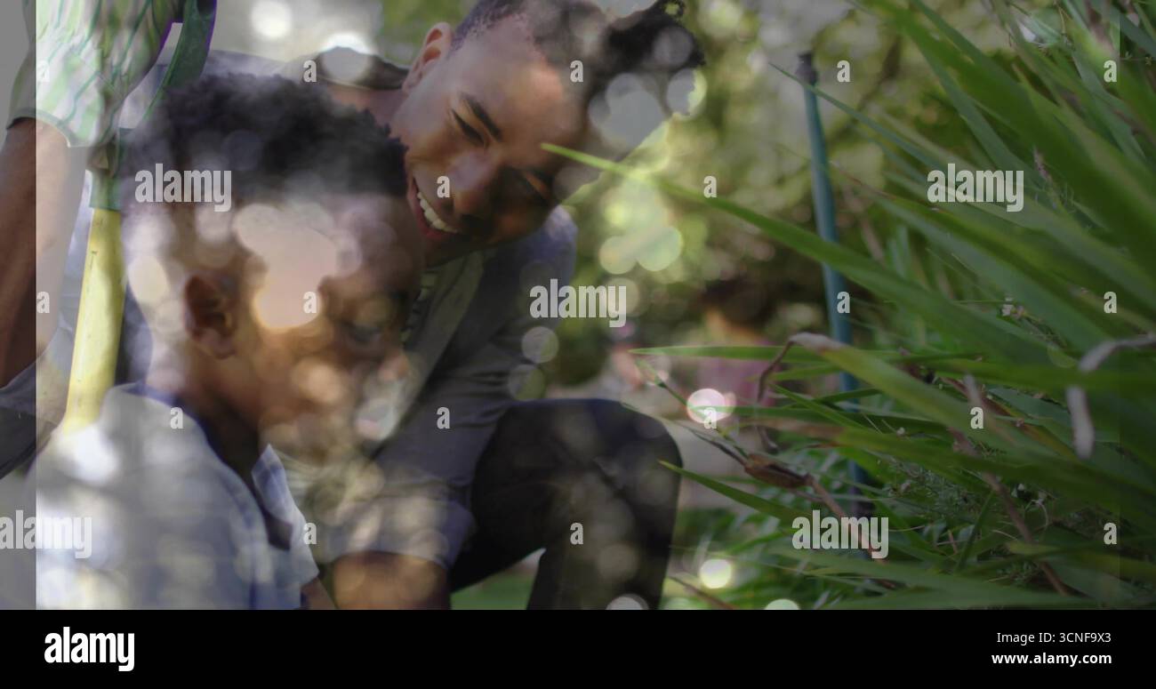Plantation père et fils agenouillés ensemble dans le jardin de l'arrière-cour, avec truelle à main et pot en argile Banque D'Images