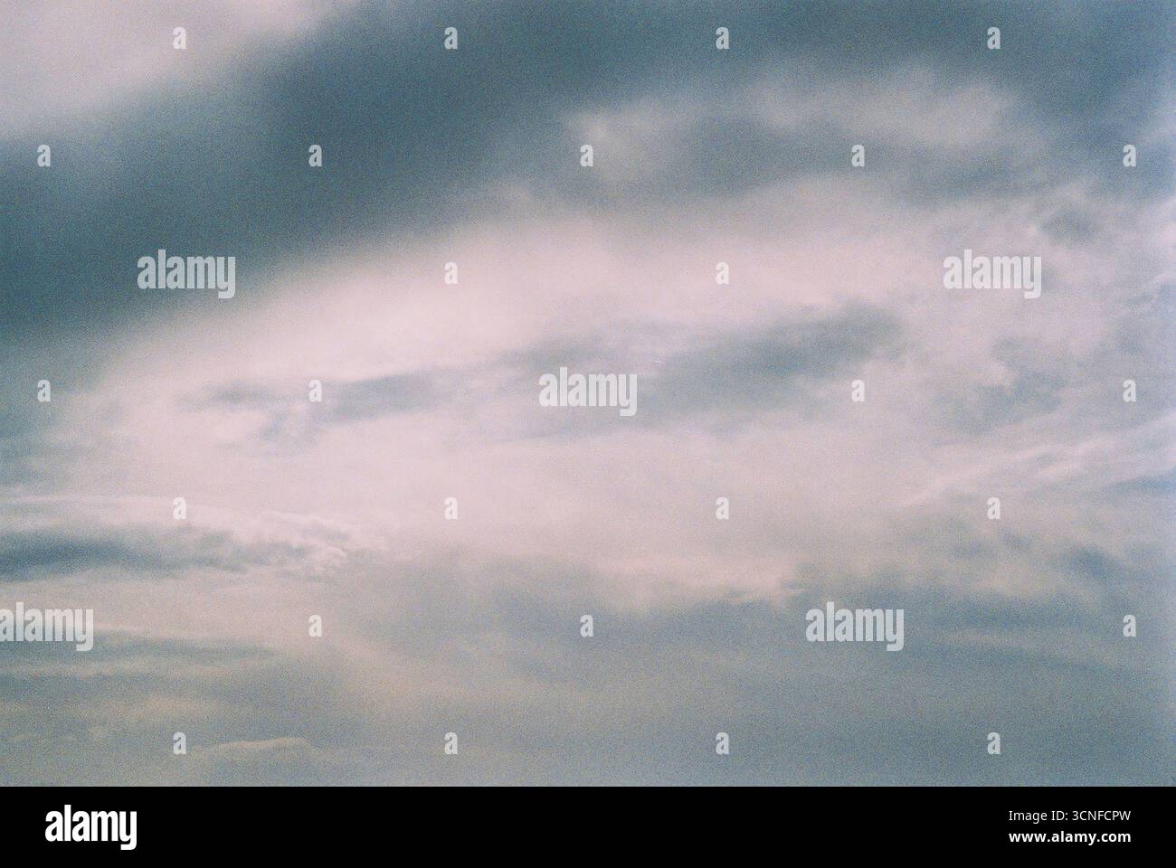 Photographie analogique de nuages capturés de manière poétique et abstraite. Textures douces, formes organiques et atmosphère émotionnelle dans un regard vers le ciel. Banque D'Images
