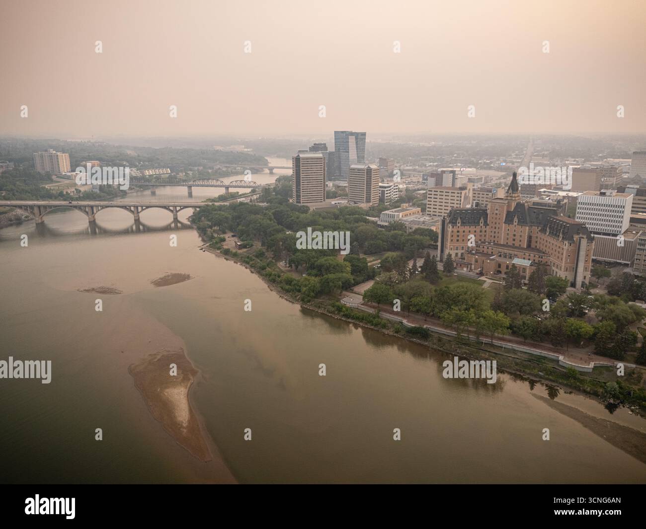Vue aérienne du centre-ville de Saskatoon, Saskatchewan, avec de la fumée de feu de forêt qui brumise la ligne d'horizon et la vallée de la rivière. Banque D'Images