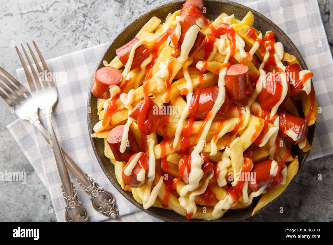 Salchipapas est un plat de restauration rapide sud-américain et caribéen composé de saucisses de bœuf poêlées finement tranchées et de frites en gros plan sur l'assiette Banque D'Images