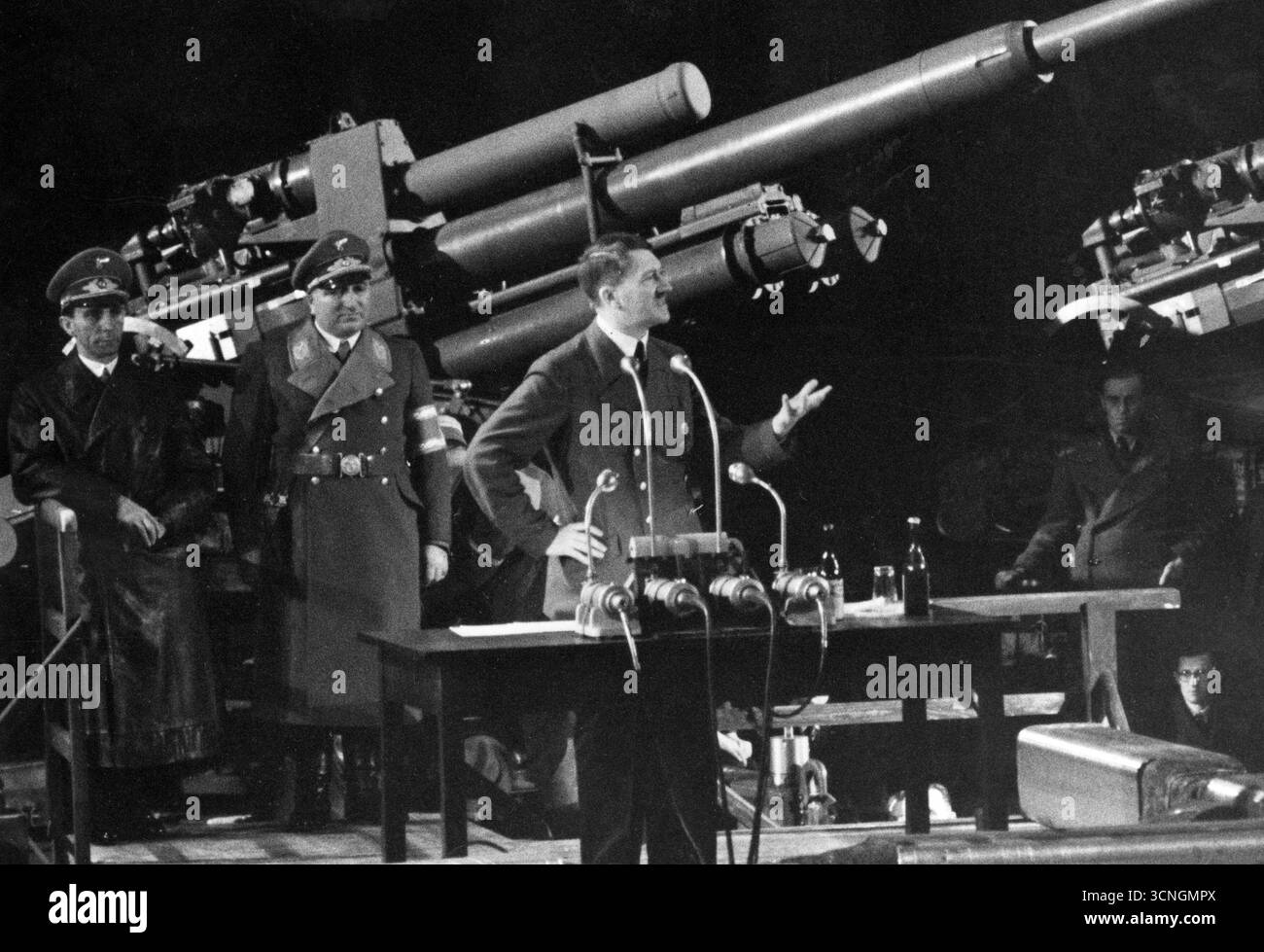 Discours d'Adolf Hitler. Hitler s'adresse aux travailleurs. À côté de lui à gauche se trouvent le leader du Front travailliste allemand Robert Ley et le Reichsminister Joseph Gobbels. Un canon est visible en arrière-plan, 1940 Banque D'Images