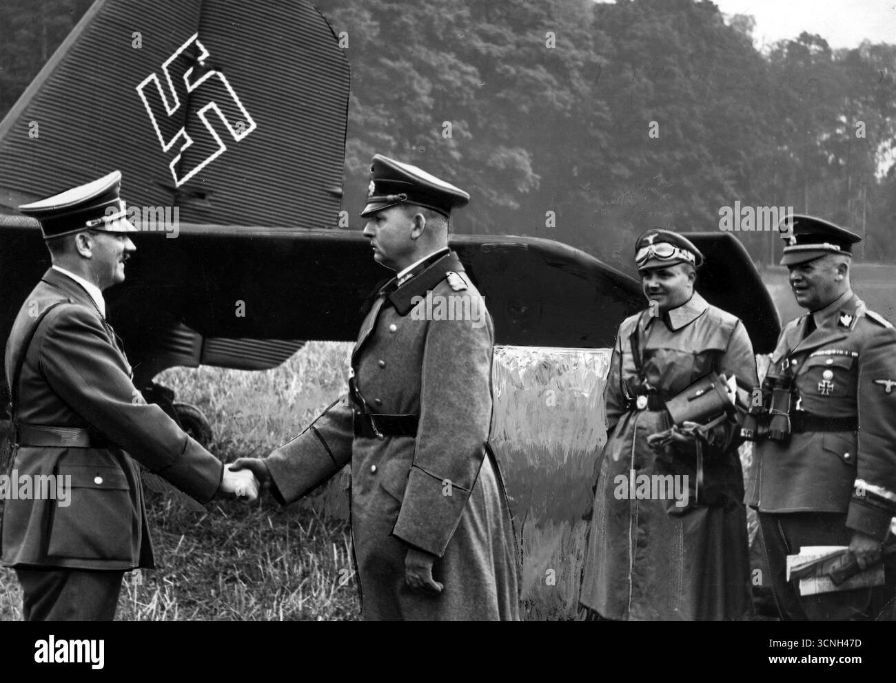 Chef du troisième Reich Adolf Hitler (à gauche) en conversation avec le général Wilhelm List. Avion allemand avec swastika en arrière-plan. 1942 - vieille photo de presse retouchée Banque D'Images