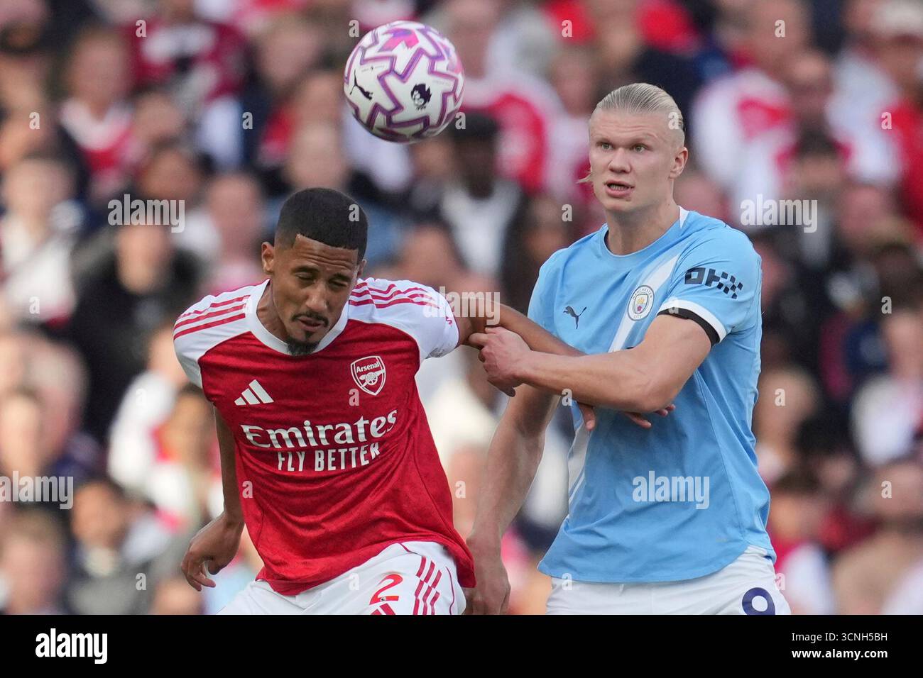 Arsenal's William Saliba, left, and Manchester City's Erling Haaland fight for the ball during the Premier League soccer match between Arsenal and Manchester City in London, Sunday, Sept. 21, 2025. (AP Photo/Kin Cheung) Banque D'Images