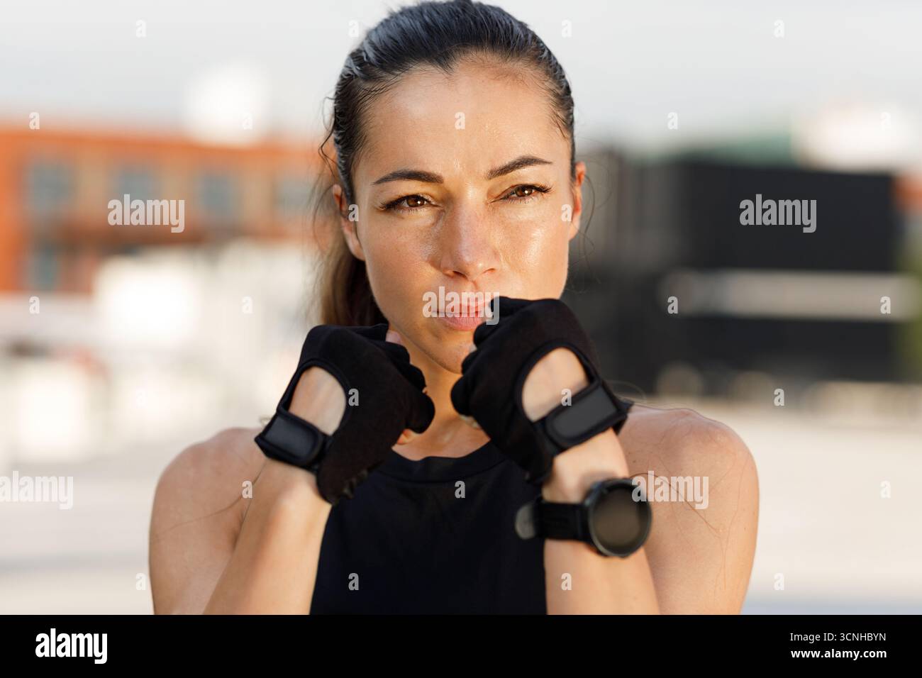Portrait rapproché d'une jeune femme dans une position de combat, prête pour la boxe d'ombre en plein air Banque D'Images