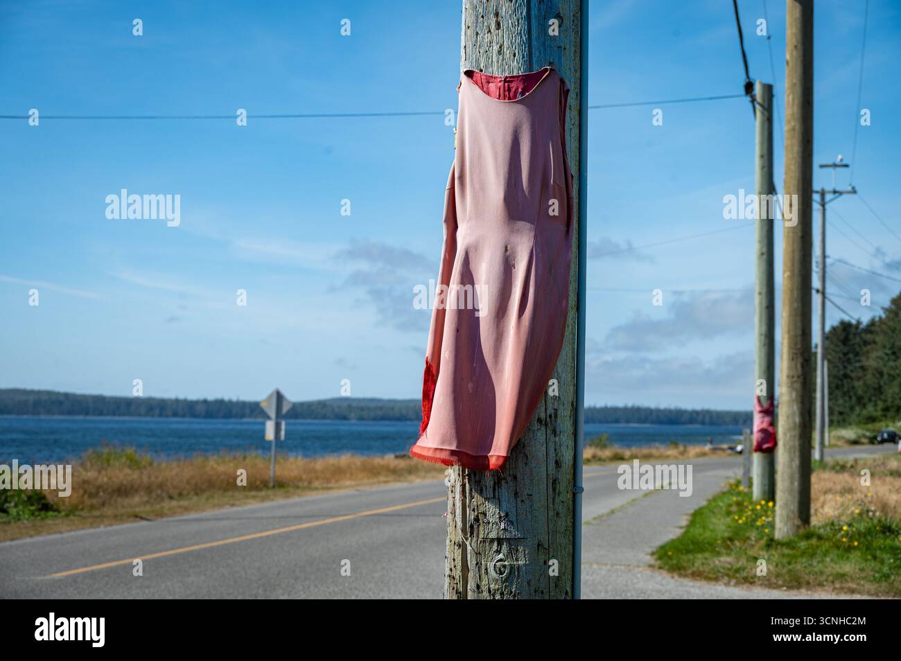 Une des nombreuses robes rouges sur l'avenue Raven, dans la réserve de la première nation haïda. Les robes symbolisent les femmes autochtones disparues et assassinées. Banque D'Images