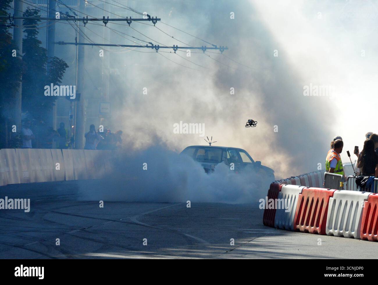 Sam Sam exécutant un impressionnant spectacle de dérive avec une BMW E30 325i à Budapest, produisant une fumée de pneu massive et divertissant la foule excitée Banque D'Images