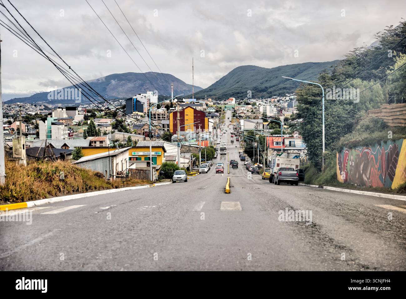 Une vue colorée sur une rue centrale du centre-ville d'Ushuaia, avec des bâtiments modernes de faible hauteur, des passages pour piétons et des vues lointaines sur le canal Beagle Banque D'Images Une vue colorée sur une rue centrale du centre-ville d'Ushuaia, avec des bâtiments modernes de faible hauteur, des passages pour piétons et des vues lointaines sur le canal Beagle Banque D'Images
