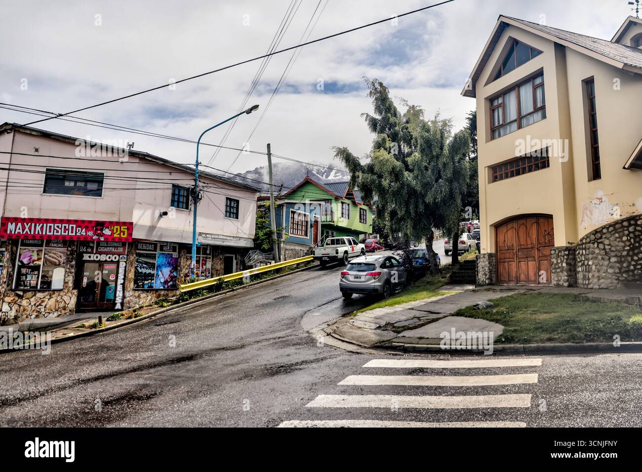Une vue colorée sur une rue centrale du centre-ville d'Ushuaia, avec des bâtiments modernes de faible hauteur, des passages pour piétons et des vues lointaines sur le canal Beagle Banque D'Images Une vue colorée sur une rue centrale du centre-ville d'Ushuaia, avec des bâtiments modernes de faible hauteur, des passages pour piétons et des vues lointaines sur le canal Beagle Banque D'Images