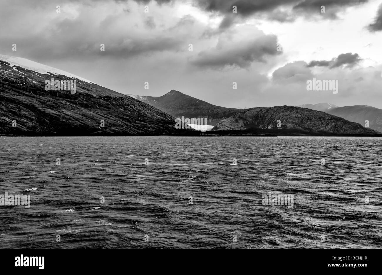 Une séquence spectaculaire de sommets enneigés et de vallées alimentées par des glaciers se déroule le long du canal Beagle près d'Ushuaia, avec des cieux changeants et des prises de vue lumineuses Banque D'Images