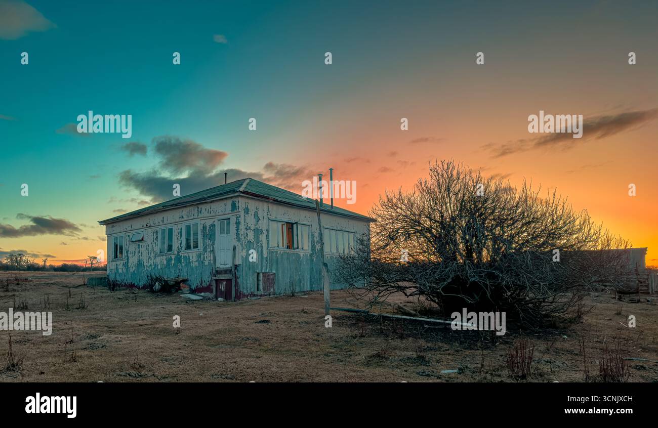 Maison de ranch détériorée sur un beau coucher de soleil Banque D'Images