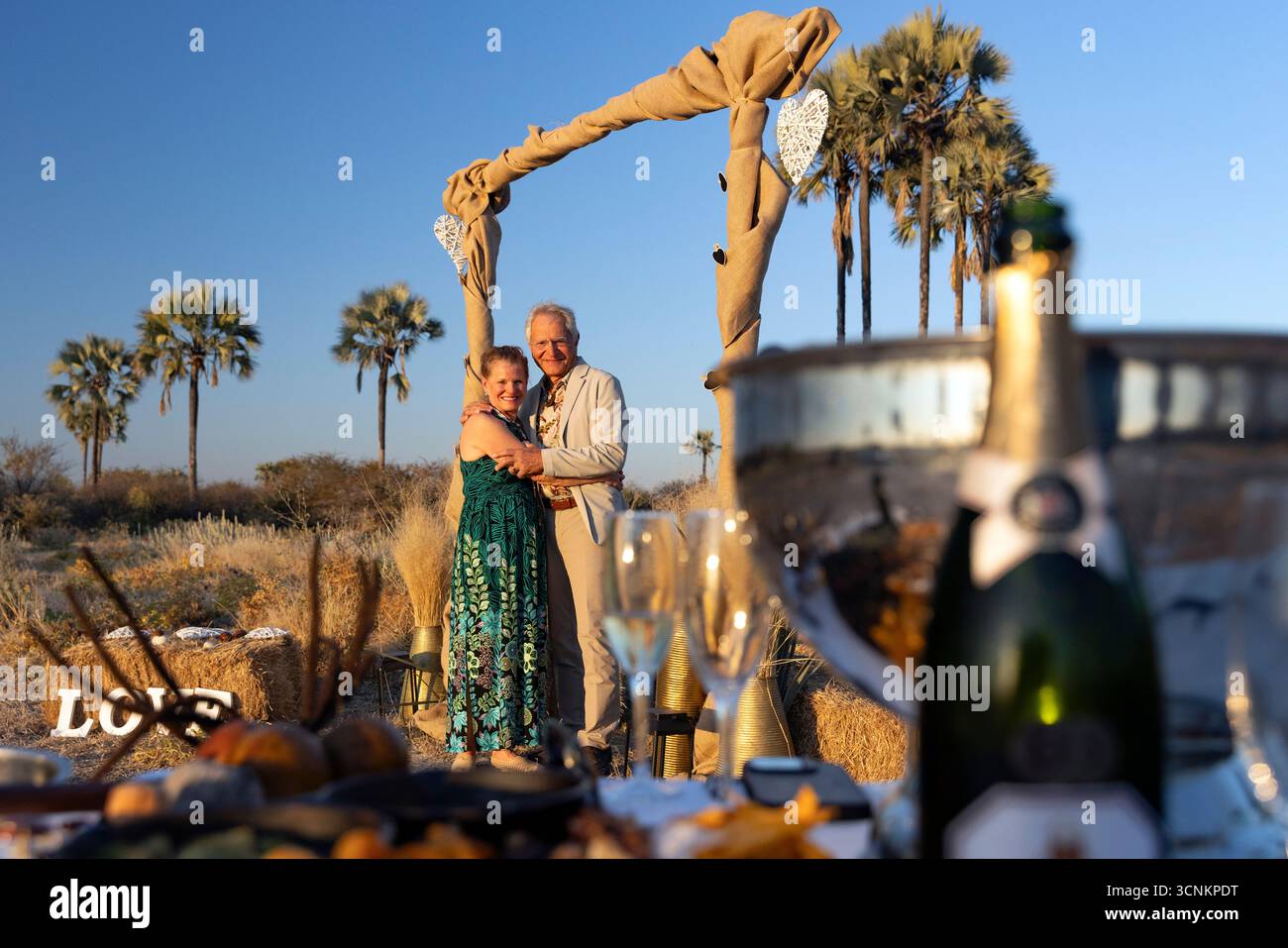 Couple de mariage sous une tonnelle de mariage dans la forêt de palmiers Makalani - réserve naturelle d'Onguma, Namibie, Afrique Banque D'Images