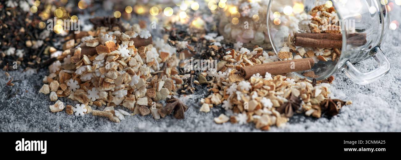 ingrédient de boisson chaude d'hiver renversé avec des épices, du sucre et une tasse de verre retournent sur fond neigeux Banque D'Images