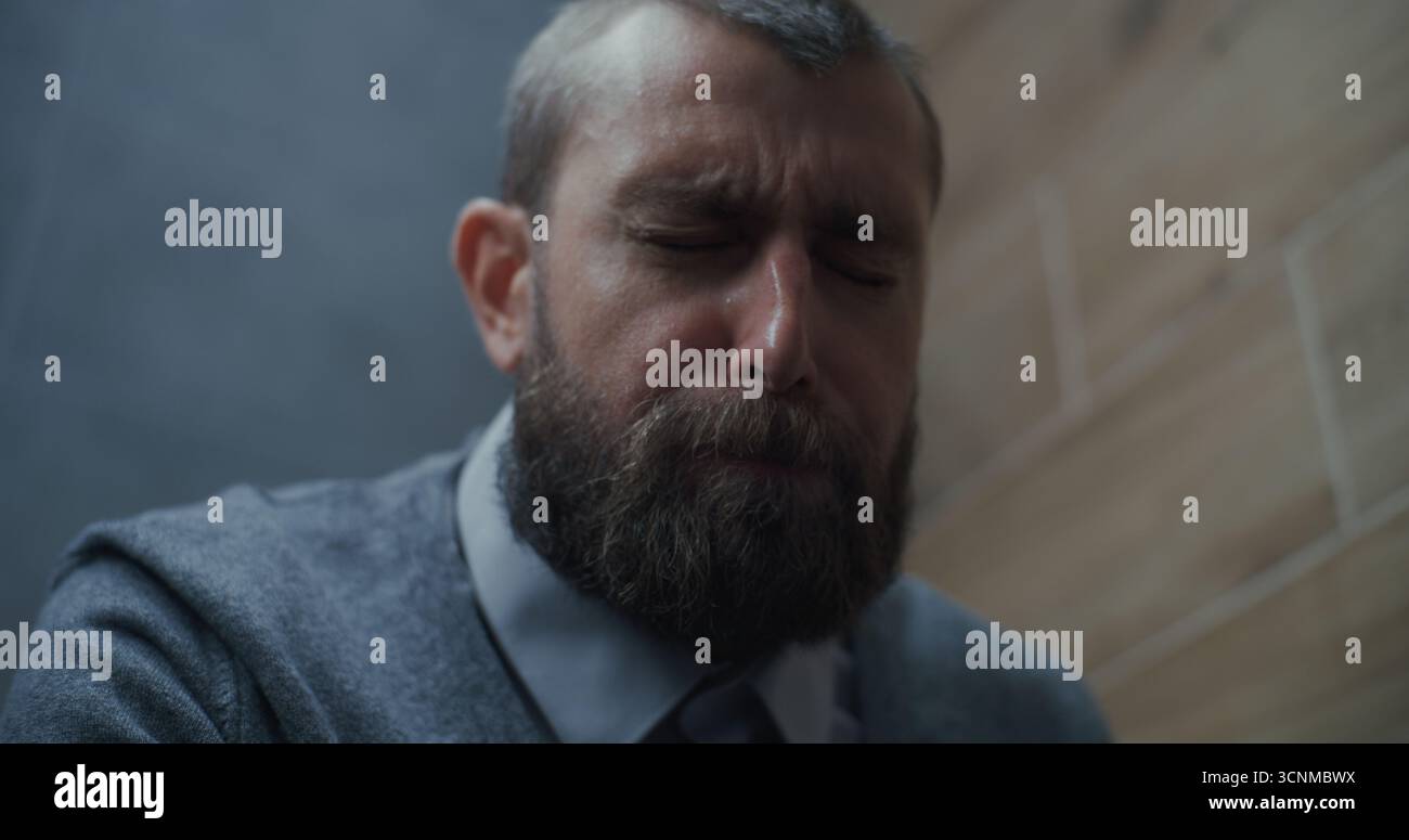 Homme d'affaires souffrant de diarrhée et d'indigestion, assis sur les toilettes. Homme éprouvant des douleurs abdominales, des maux d'estomac et de l'inconfort digestif dans les toilettes modernes de bureau pendant le travail. Gros plan. Banque D'Images