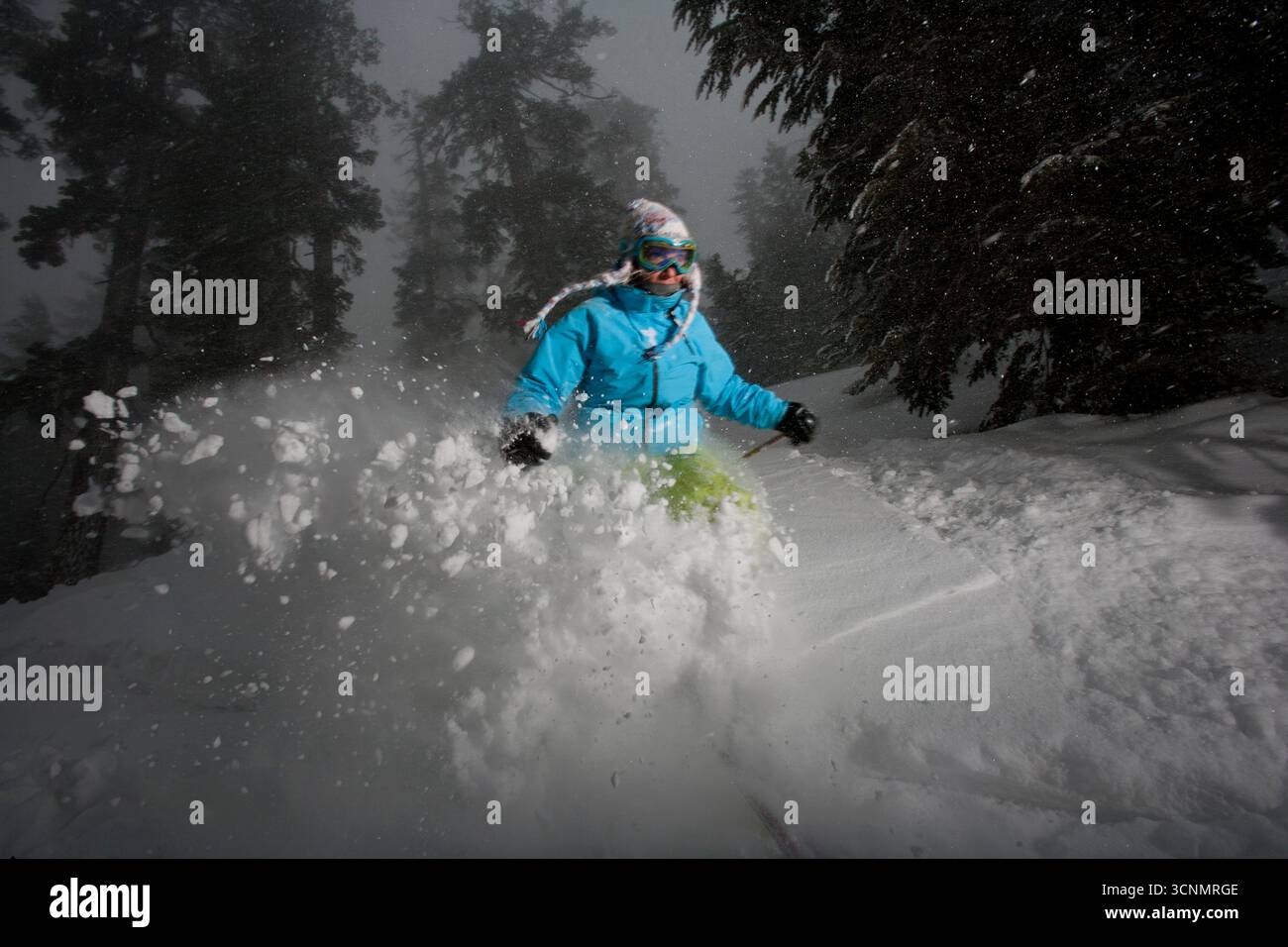 Une femme skie sur une piste poudreuse dans une station de ski en Californie. Banque D'Images