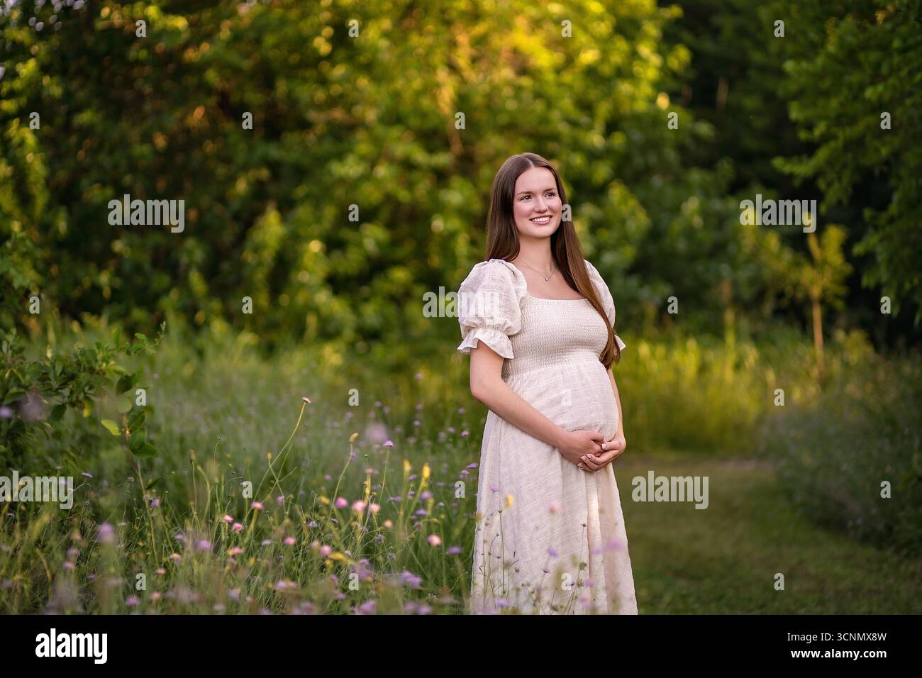 mère enceinte brillante dans un champ de fleurs sauvages Banque D'Images