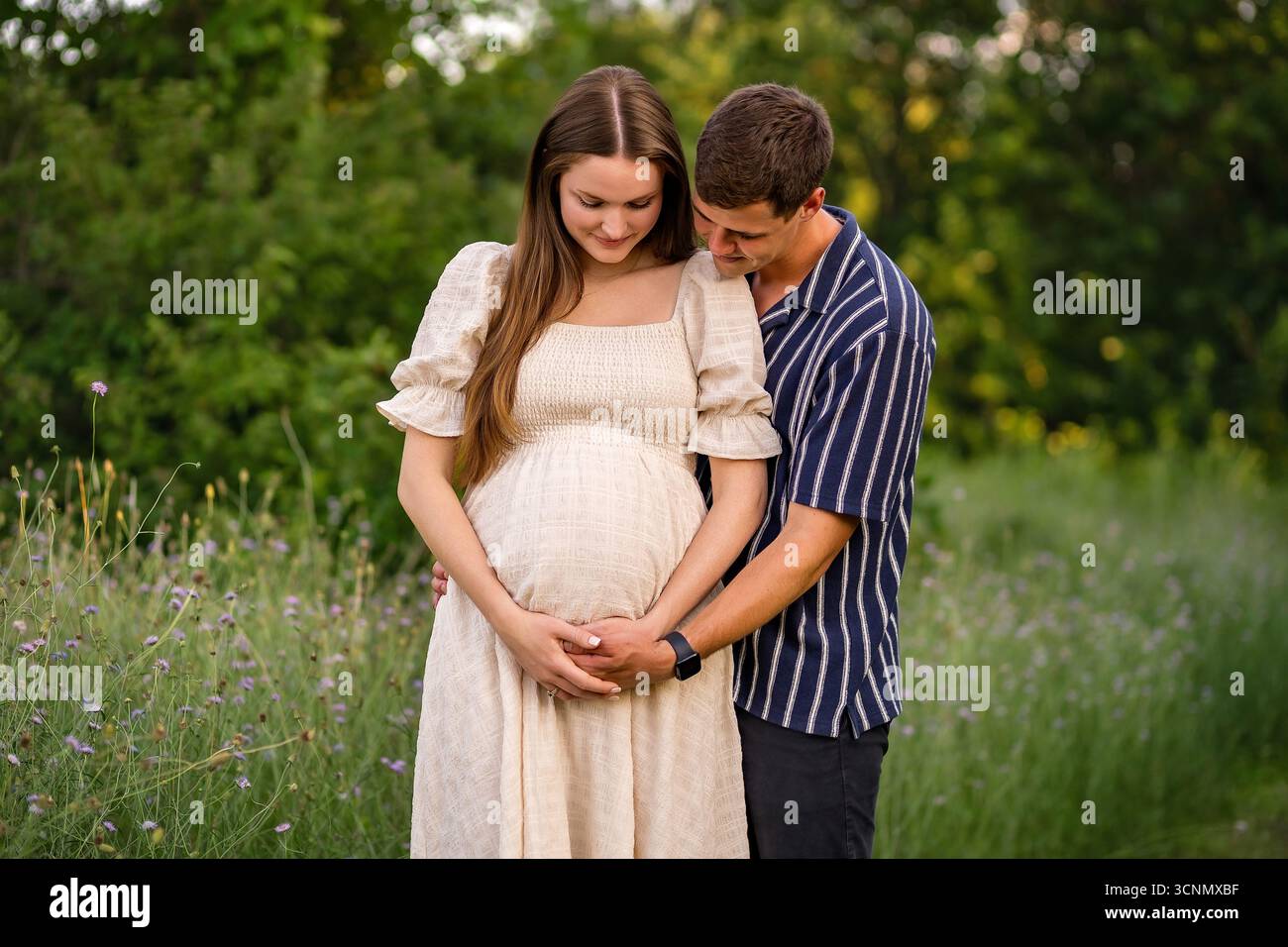 une mère enceinte regarde le ventre de son bébé avec son partenaire Banque D'Images
