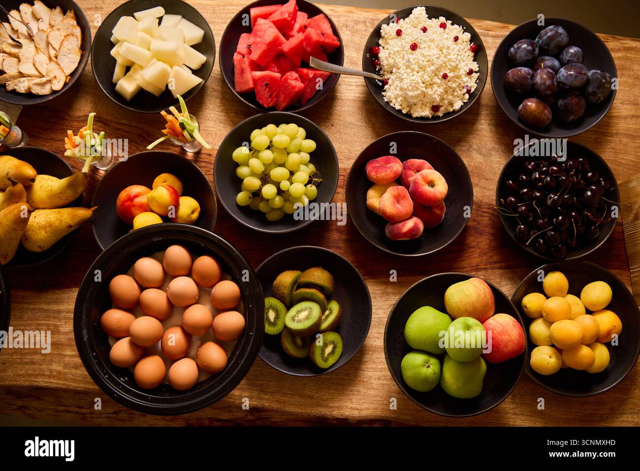 Affichage de fruits et d'œufs sur une table en bois lors d'un rassemblement vibrant Banque D'Images