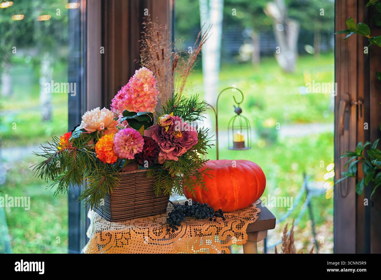 Automne halloween décor dans le salon avec citrouille et fleurs, fenêtre donnant sur la cour sur fond. Lumière chaude naturelle. Petite profondeur de fie Banque D'Images