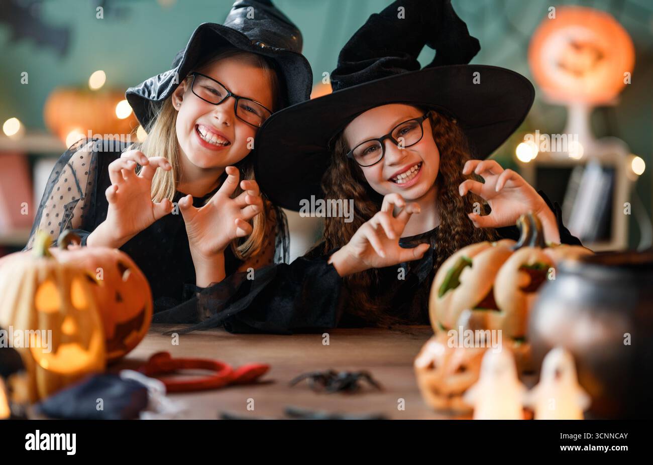 Deux filles en costumes de sorcière célèbrent Halloween. Enfants avec des citrouilles Banque D'Images