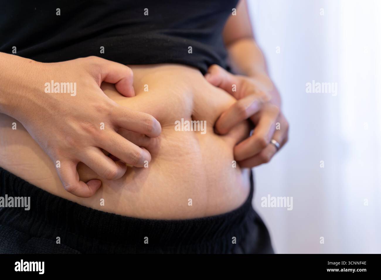 Femme asiatique pressant sa graisse du ventre, concept de perte de poids, alimentation saine, soins du corps et mode de vie physique. Banque D'Images