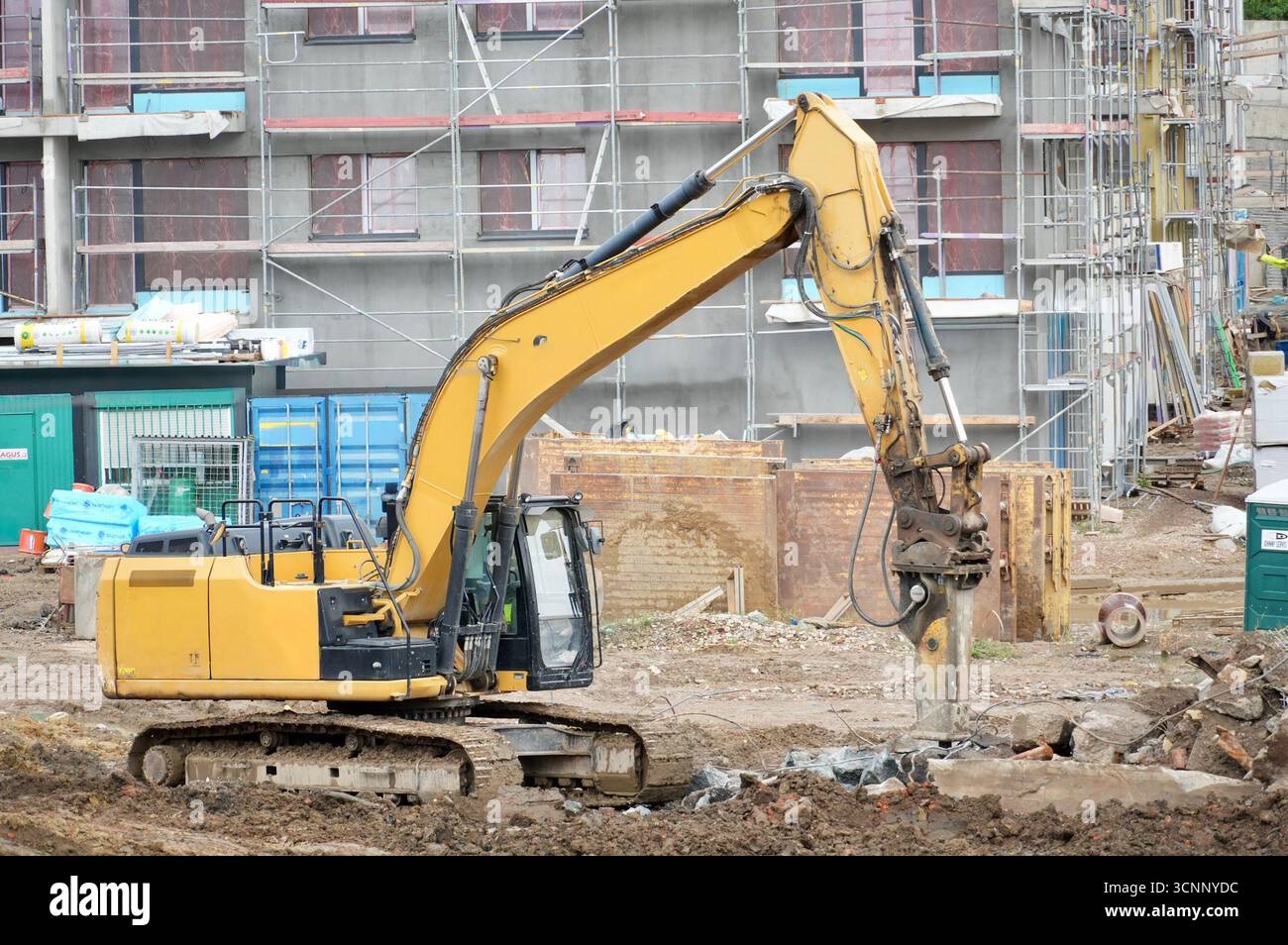 excavatrice sur un chantier de construction sur un fond de bâtiment en construction Banque D'Images
