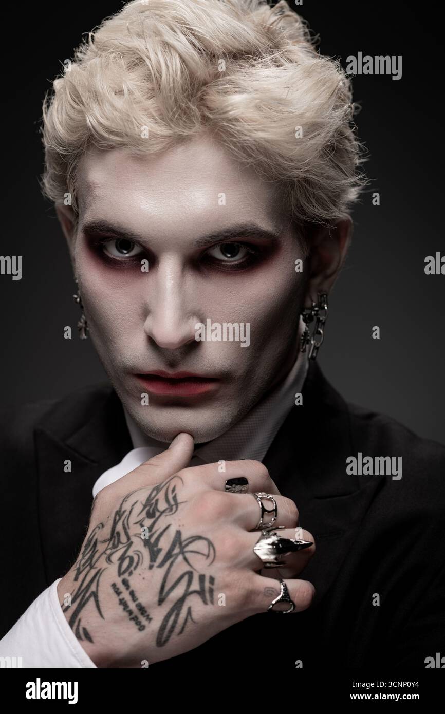 Un jeune homme montre son incroyable costume d'Halloween avec un maquillage audacieux et des accessoires détaillés. Banque D'Images