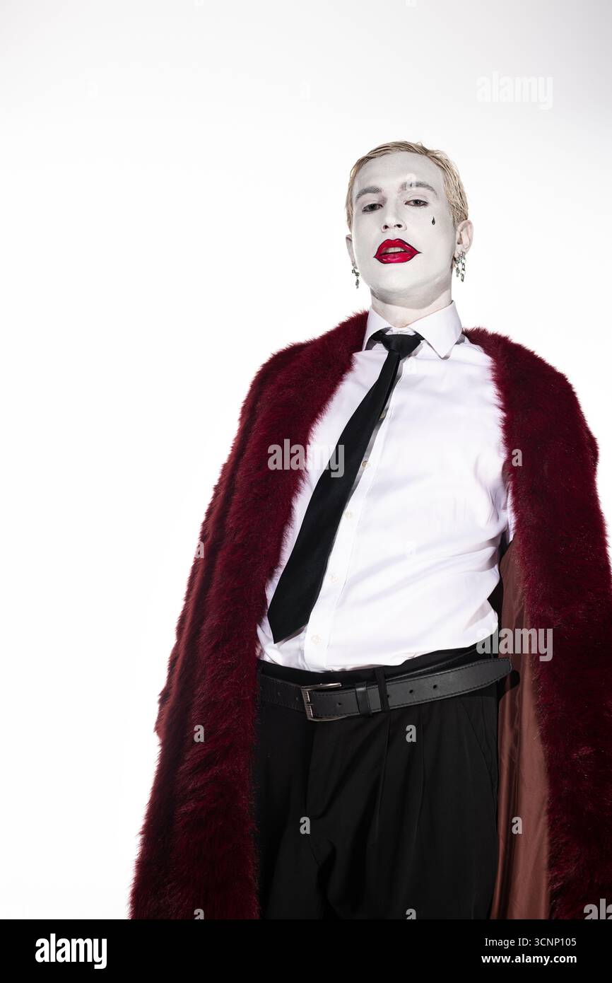 Jeune homme habillé en Joker captive avec un costume d'Halloween frappant et une pose confiante. Banque D'Images