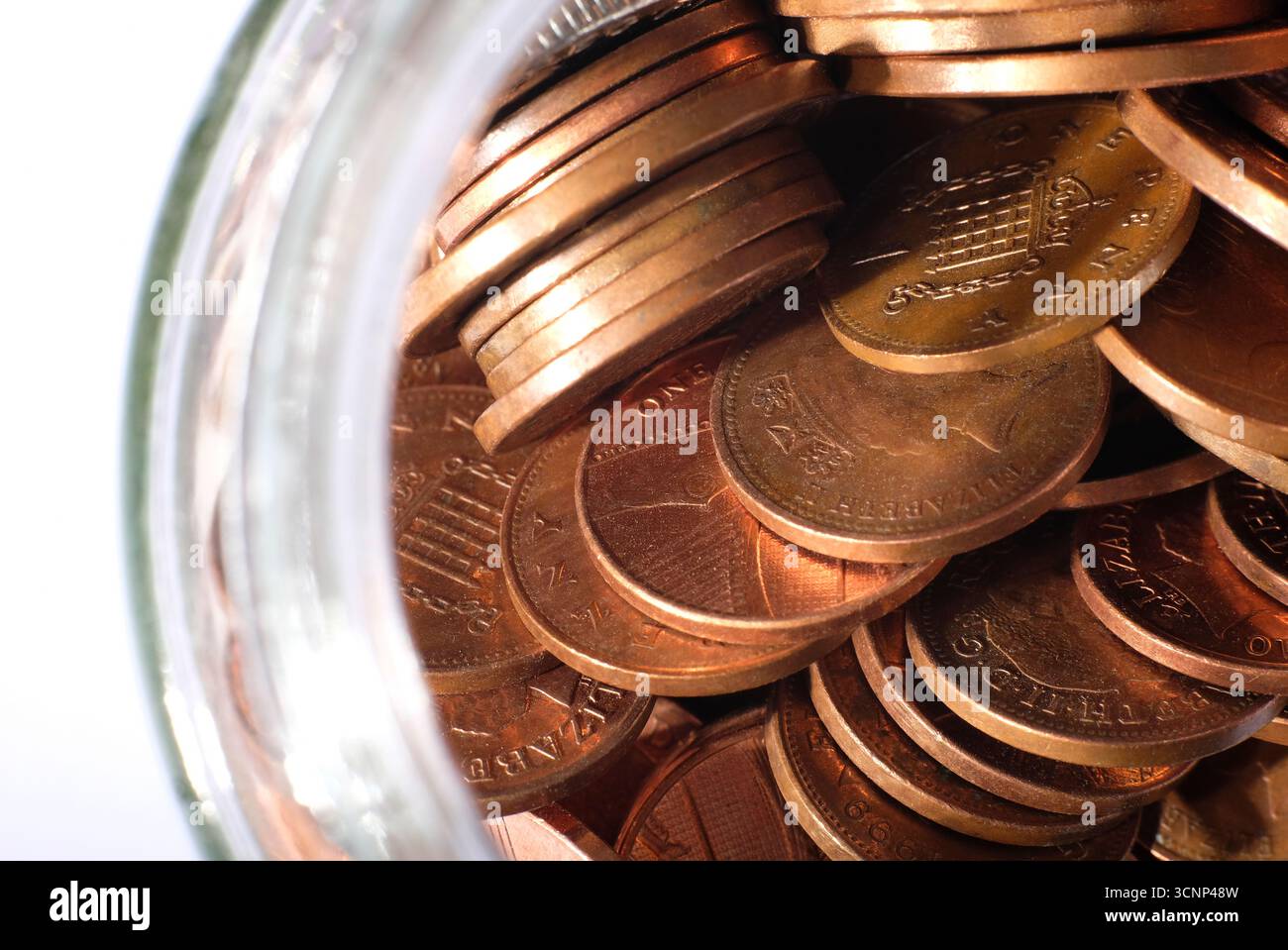 pièces de monnaie britanniques en pot en verre sur fond blanc Banque D'Images