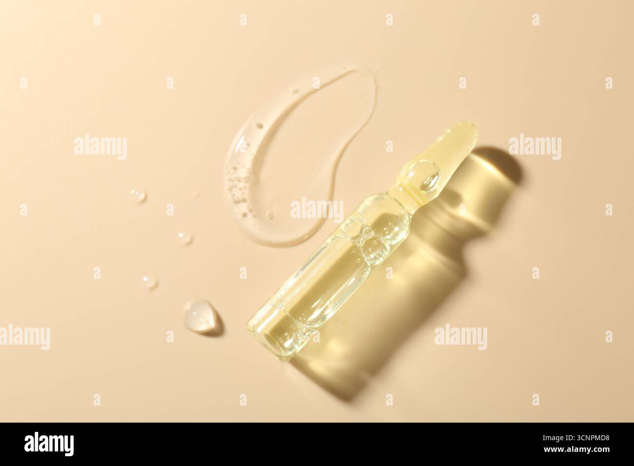 Ampoule en verre avec produit cosmétique et échantillon sur fond beige, vue de dessus. Espace pour le texte Banque D'Images