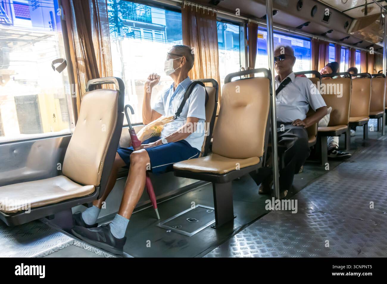 Hommes âgés assis dans un bus, transports en commun à Bangkok Thaïlande Banque D'Images