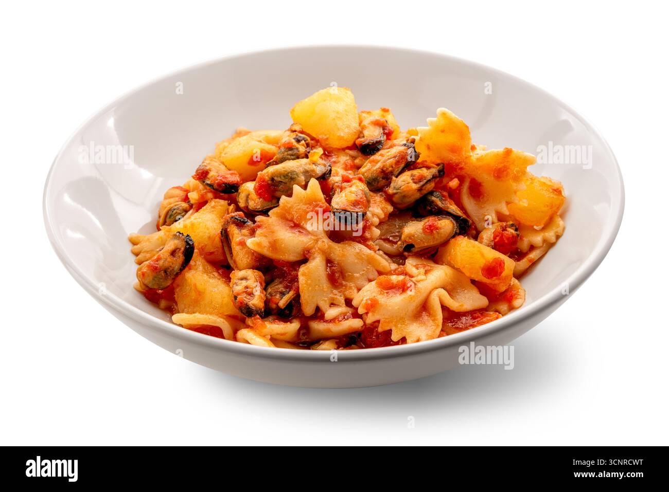 Pâtes Bow Tie avec moules et pommes de terre en sauce tomate sur une assiette blanche isolée sur blanc avec chemin de coupe inclus Banque D'Images