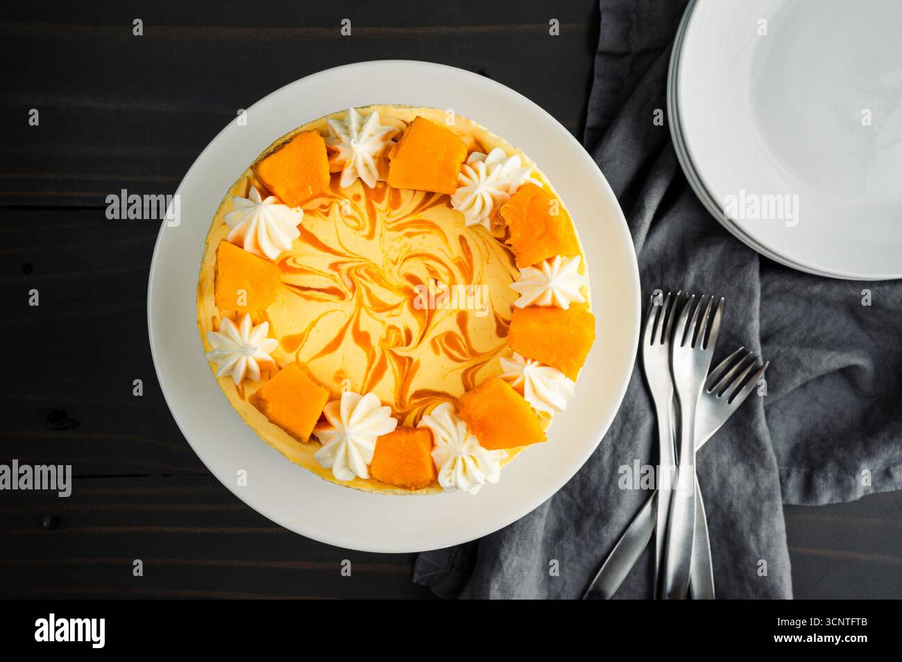 Vue aérienne du gâteau mousse à la mangue : directement au-dessus d'un gâteau mousse avec tourbillon de mangue, glaçage au fromage à la crème et décorations de mangue fraîche Banque D'Images