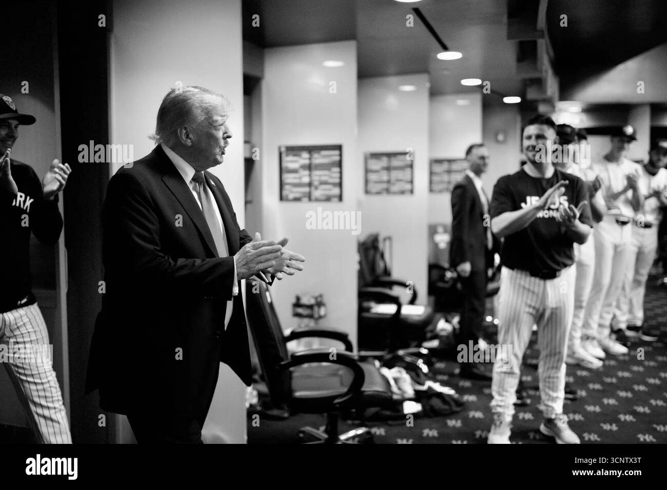 Le président Donald Trump s’entretient avec l’équipe des New York Yankees dans leur club-House du Yankee Stadium. Les joueurs écoutent dans des uniformes pleins à fines rayures. New York, États-Unis. 11 septembre 2025. Banque D'Images