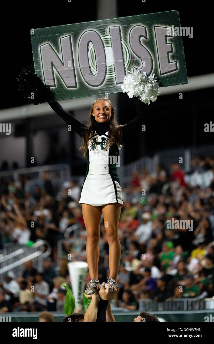 Au cœur de l’intensité des jours de match, une pom-pom-pom-meneuse de l’Université d’Hawaï commande la foule avec un signe audacieux de « BRUIT » vs Fresno State Bulldogs. Banque D'Images