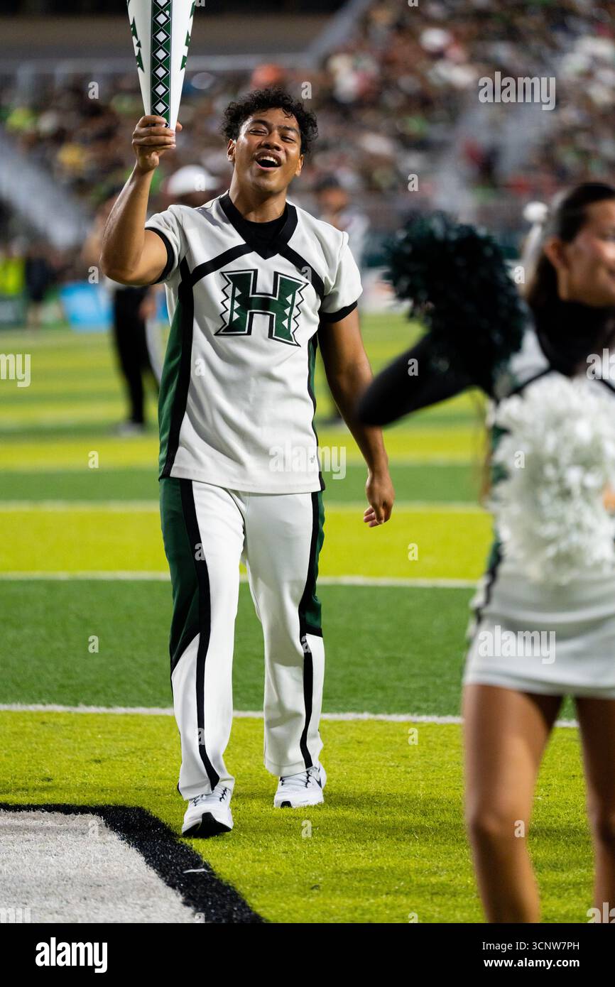 Avec une passion et une force imparables, les bases de pom-pom-pom de l'Université d'Hawaï mènent la charge, alimentant l'énergie de la foule dans une bataille de football intense Banque D'Images Avec une passion et une force imparables, les bases de pom-pom-pom de l'Université d'Hawaï mènent la charge, alimentant l'énergie de la foule dans une bataille de football intense Banque D'Images