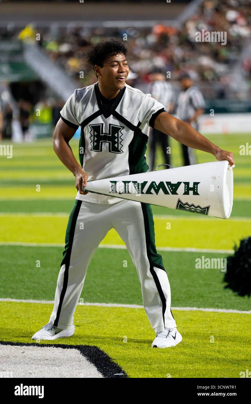 Avec une passion et une force imparables, les bases de pom-pom-pom de l'Université d'Hawaï mènent la charge, alimentant l'énergie de la foule dans une bataille de football intense Banque D'Images Avec une passion et une force imparables, les bases de pom-pom-pom de l'Université d'Hawaï mènent la charge, alimentant l'énergie de la foule dans une bataille de football intense Banque D'Images