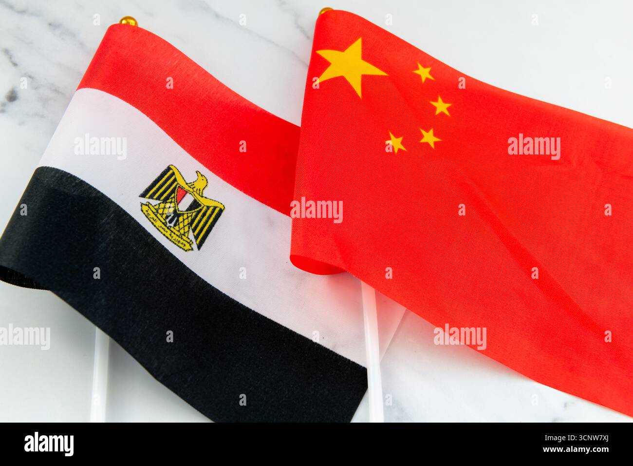 Le drapeau national égyptien sur le mât du drapeau à côté du drapeau national de la Chine. Un concept de relations entre l'Egypte et la Chine. Banque D'Images