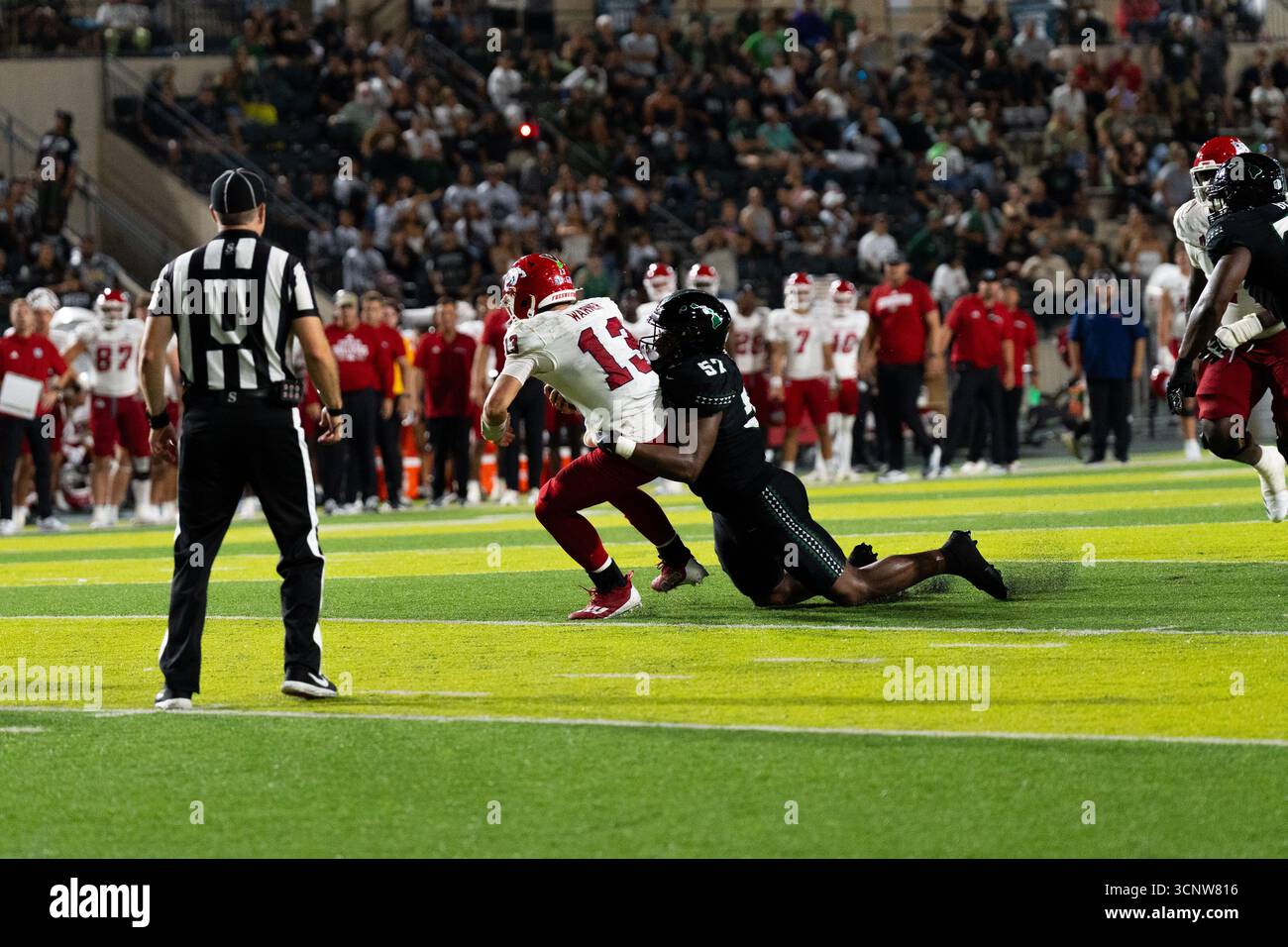 Fresno State QB E.J. Warner se bat contre les défenseurs d'Hawaï dans une victoire étroite de 23 à 21, montrant l'agilité sous pression. Banque D'Images