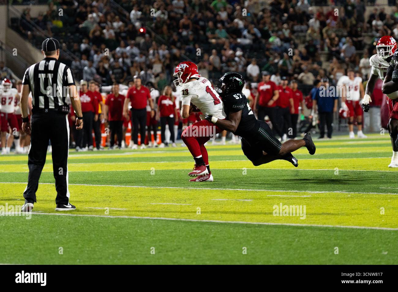 Fresno State QB E.J. Warner se bat contre les défenseurs d'Hawaï dans une victoire étroite de 23 à 21, montrant l'agilité sous pression. Banque D'Images