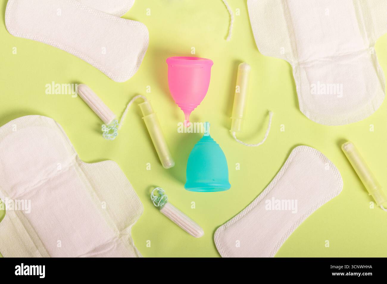 Vue aérienne des produits de santé menstruelle, y compris les coupes menstruelles colorées, les tampons et les serviettes hygiéniques. Met l'accent sur les soins périodiques écologiques et la sust Banque D'Images