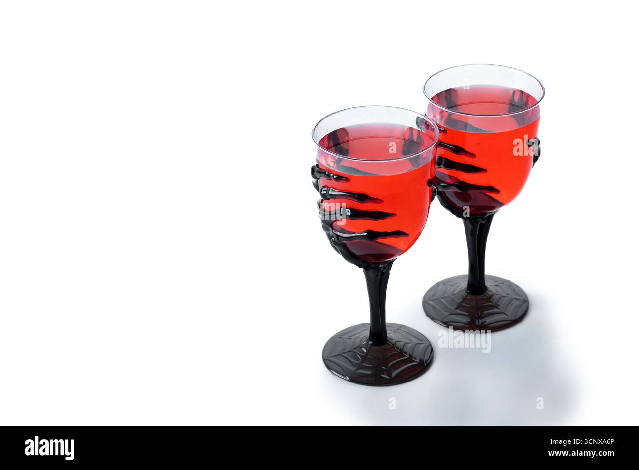Halloween cocktail rouge effrayant dans le verre à main squelette isolé sur fond blanc Banque D'Images