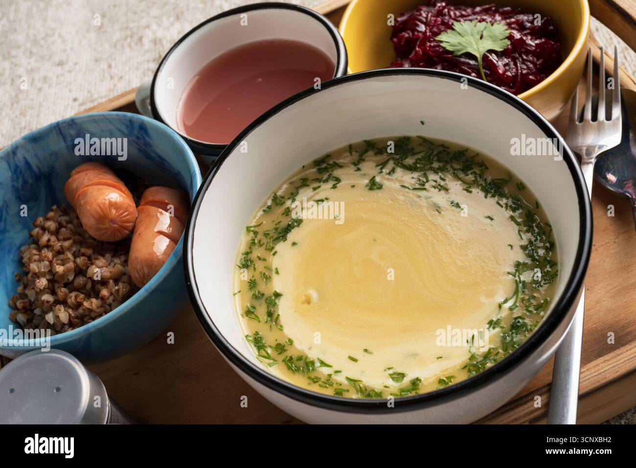 Déjeuner complet à la cafétéria servi sur plateau : soupe chaude, saucisse avec accompagnement et salade fraîche. Concept de repas institutionnel pour l'école, le travail ou la cantine di Banque D'Images