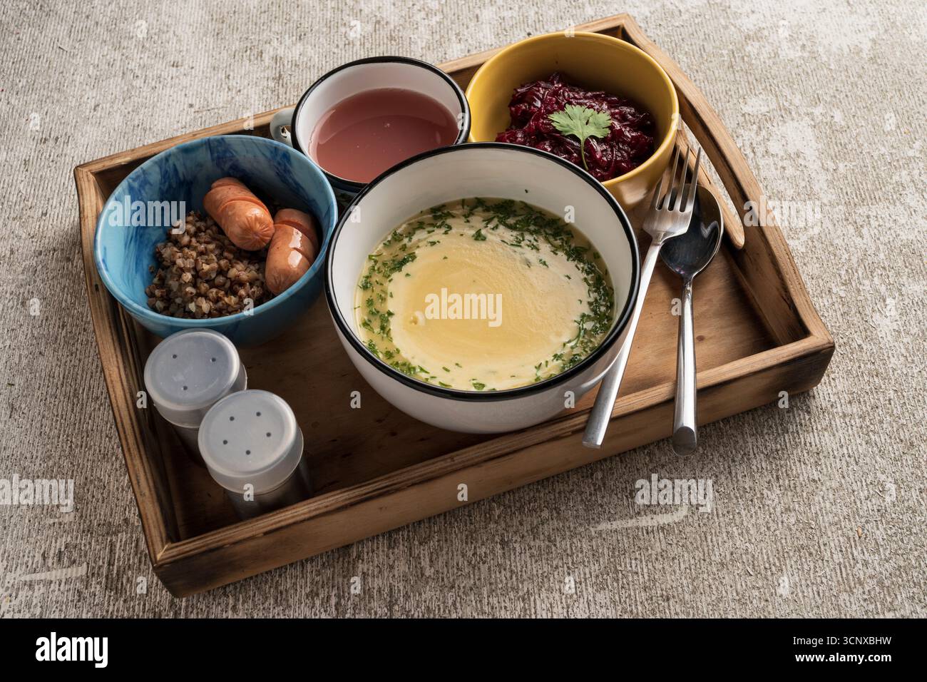 Déjeuner complet à la cafétéria servi sur plateau : soupe chaude, saucisse avec accompagnement et salade fraîche. Concept de repas institutionnel pour l'école, le travail ou la cantine di Banque D'Images