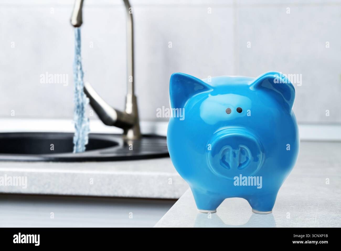 Concept Save Water. Tirelire et robinet avec de l'eau qui coule, mise au point sélective Banque D'Images