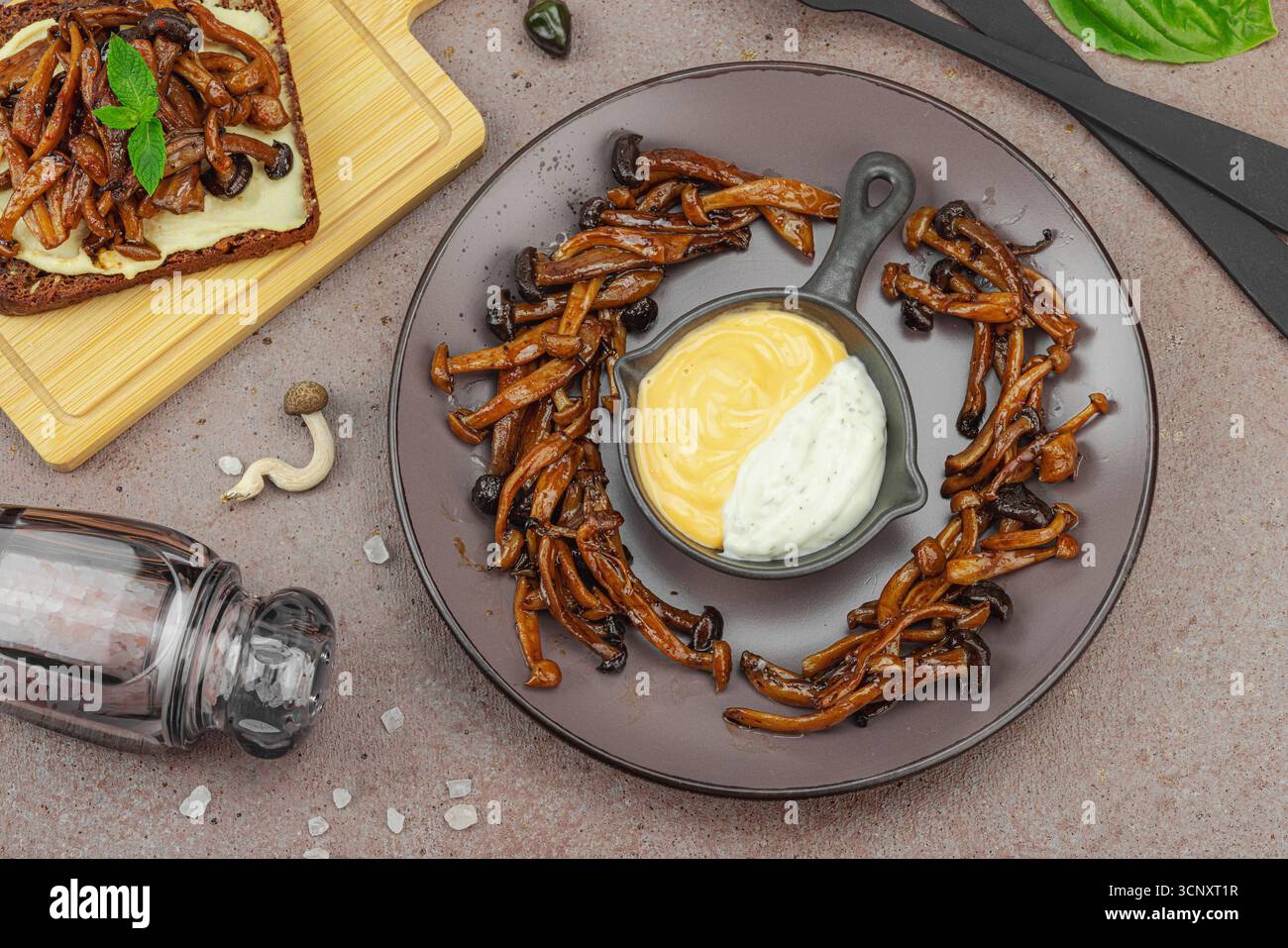 Sandwichs ouverts sains à base de plantes avec champignons Shimeji sautés. Repas végétalien riche en protéines est servi sur une assiette blanche, fond de pierre chaud, vie supérieure Banque D'Images