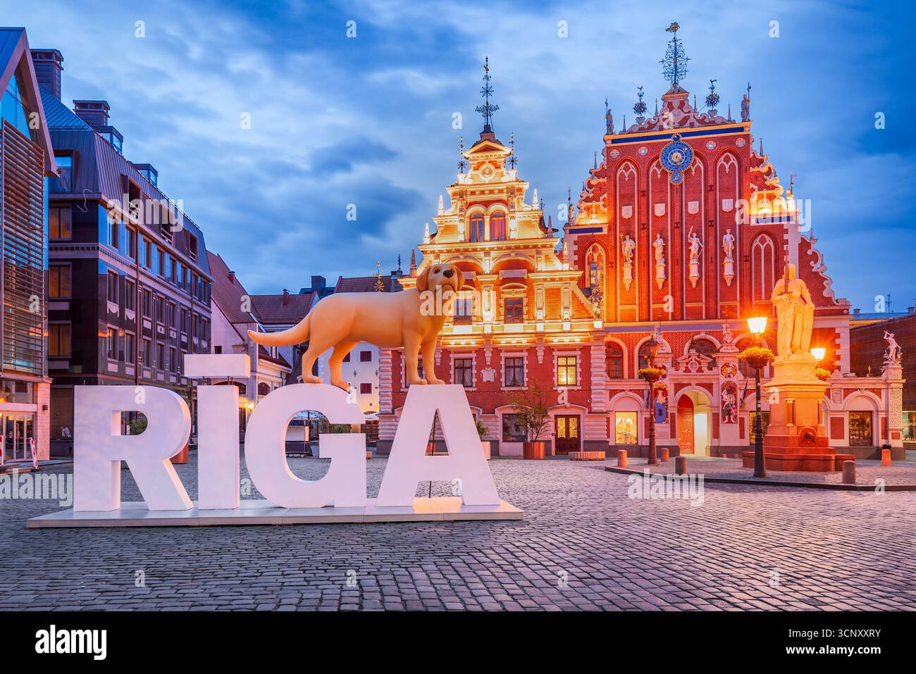 Riga, Lettonie - 05 juin 2025. Lettres de symbole Riga et la place de l'Hôtel de ville avec la Maison des Blackheads, coucher du soleil heures d'été. Banque D'Images