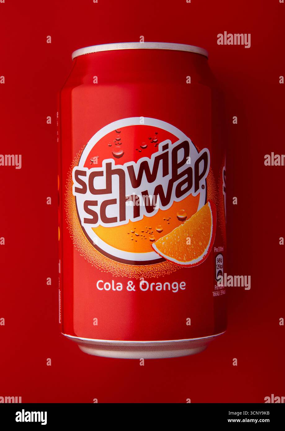 LONDRES, Royaume-Uni - 21 MARS 2025 : canette en aluminium de Schwip Schwap Cola boisson gazeuse orange sur rouge. Banque D'Images