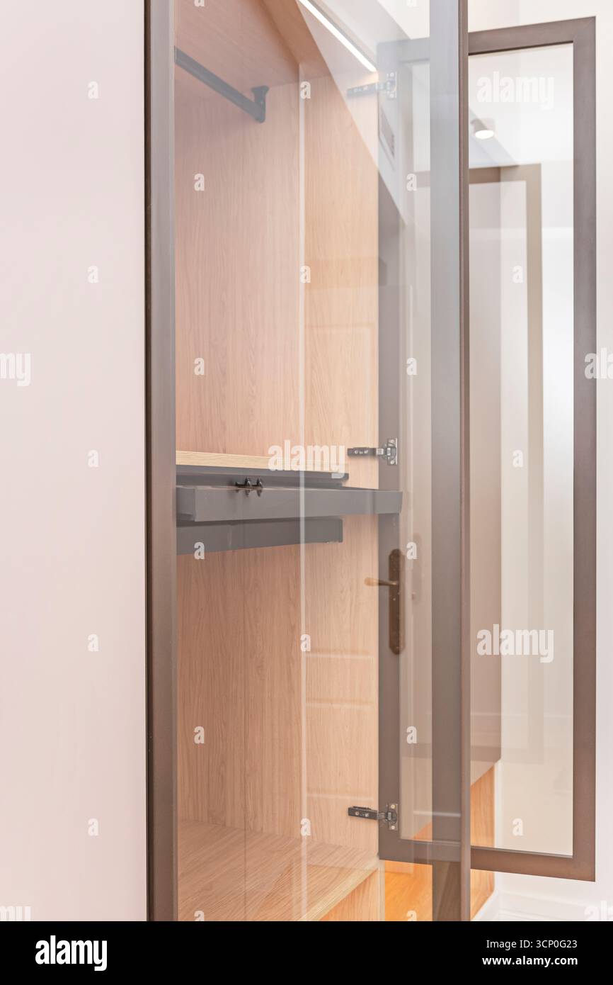 Dressing luxueux avec armoires personnalisées avec panneaux laqués, étagères intérieures éclairées Banque D'Images