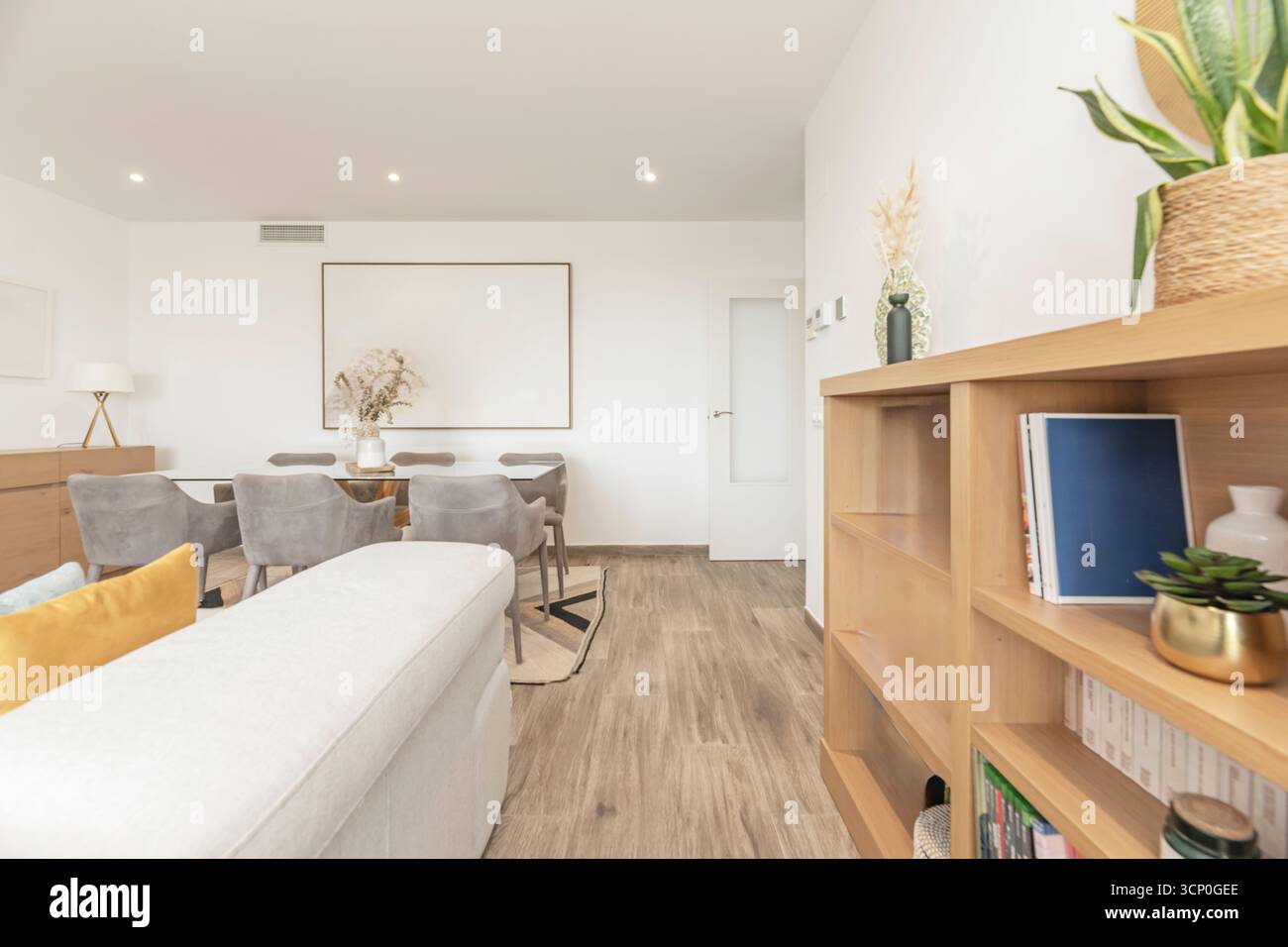 Salon et salle à manger avec canapé en velours rose, table basse dorée et salle à manger en bois avec suspension Banque D'Images