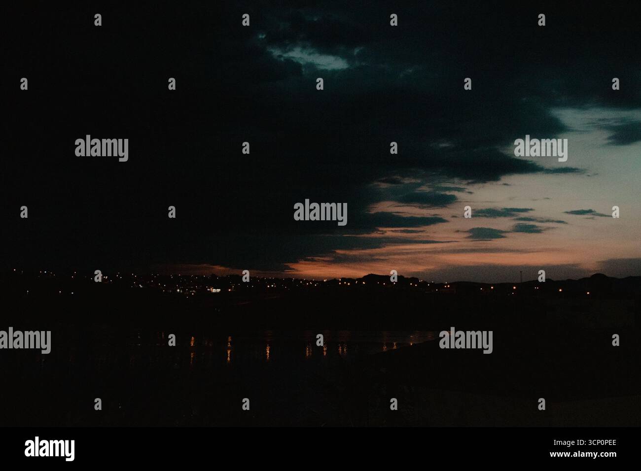 Lumières de la ville au crépuscule sous un ciel nuageux Banque D'Images